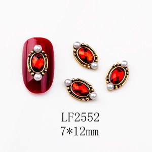 Detail of vintage red oval nail art charm with gold wavy border and tiny pearls