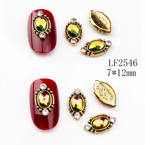Detail of 7x12mm vintage oval nail charms with colored gems and white rhinestones