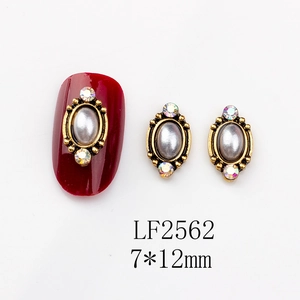 Close-up of vintage oval nail art charms with pearls and colorful rhinestones on nails