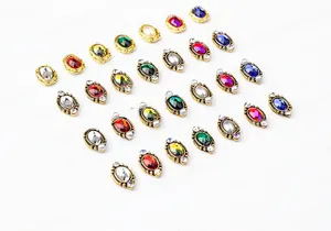 Detailed close-up of vintage baroque nail art charms with colorful oval gems and gold frames