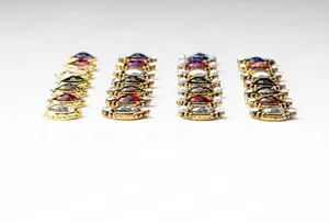 Detailed macro view of vintage alloy nail art charms with colorful oval gemstones