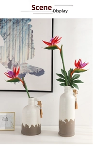 Detailed close-up of vibrant artificial Bird of Paradise flowers in a ceramic vase