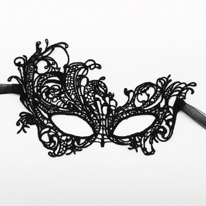 Elegant black lace masquerade mask with floral embroidery and silk ribbons on white backdrop