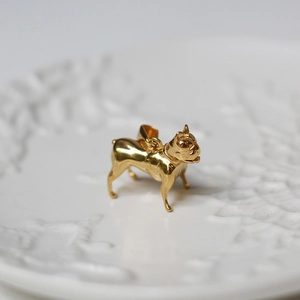 Detailed close-up of a golden French Bulldog pendant with polished metal finish
