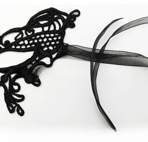 Macro detail of sexy black lace eye mask featuring intricate floral patterns and silk ribbons