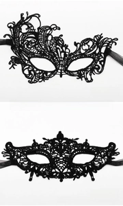 Detail of black lace masquerade masks showing intricate weaving and satin ribbon ties