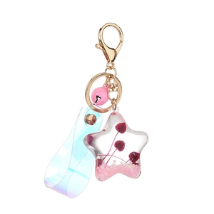 Star-shaped liquid keychain with pink bell, laser strap and dried mushroom details