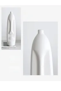 Close-up of a white ceramic face vase showing the smooth bottle mouth and matte texture