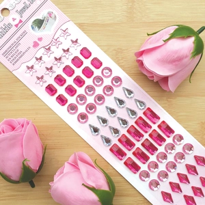 Colorful gemstone stickers in heart and star shapes on a card with pink roses decoration