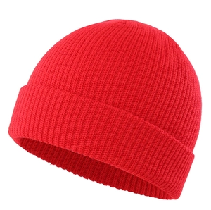 Detailed view of bright red ribbed knit beanie with rolled cuff design for winter warmth