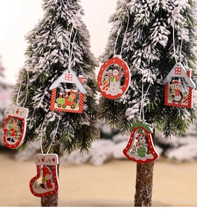 Close-up of red wooden Christmas tree ornaments hanging on snowy branches