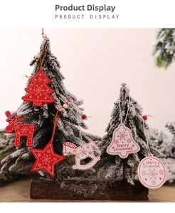 Close-up of red and white wooden Christmas ornaments with snowflake patterns on pine tree