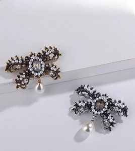 Close-up of vintage butterfly brooches with rhinestones and hanging water drop pearls