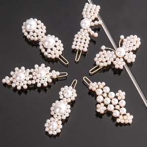 Detail view of six pearl hair clip styles on a black reflective background