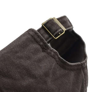 Detailed macro view of the vintage bronze buckle and washed cotton texture on a baseball cap