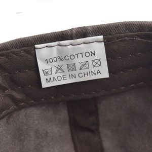 Macro view of 100% cotton fabric and washing label inside the brown baseball cap