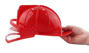 Primo piano di un casco da pompiere rosso per bambini con visiera mobile trasparente