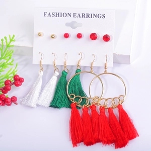 Detail of Christmas earring set with red tassels, gold hoops and festive studs on a card