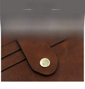 Macro shot of brown leather wallet texture with gold metal button clasp detail