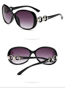 Detail view of large frame sunglasses with purple gradient lenses and silver hardware