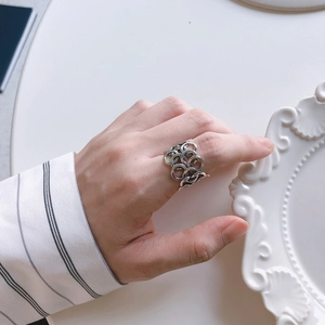 Detail view of a multi-link silver interlocking ring worn on the index finger style