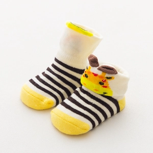 Detail of yellow baby sock featuring a 3D giraffe accent and black white stripes