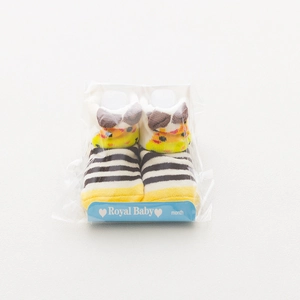 Detail of yellow and black striped baby socks with cute 3D animal ears and packaging