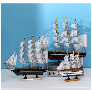 Trois modèles de voiliers en bois noir et blanc avec voiles en tissu sur socle