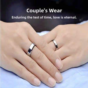Detail of silver titanium steel couple rings with polished beveled edges on a hand