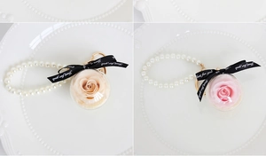 Detailed view of preserved rose keychains in acrylic balls with elegant pearl chains