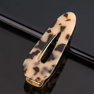 Detail shot of acetate tortoiseshell hair clip with golden metal duckbill mechanism