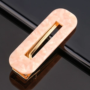 Detail shot of the pink marble resin hair clip with a polished gold metal base