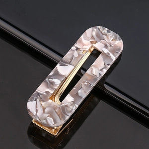 Close-up of marble pattern acetate hair clip with a gold metal spring clip