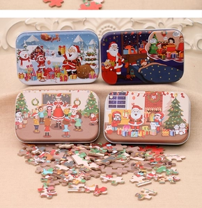Detail view of four Christmas themed tin boxes with assorted puzzle pieces and vivid scenes