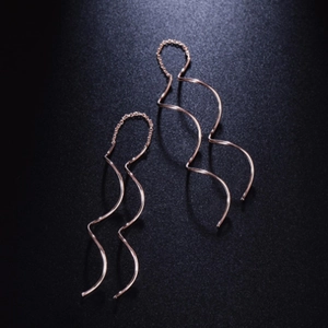 Elegant rose gold S-shaped wavy drop earrings with a polished metallic finish on a dark background