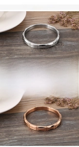 Detailweergave van bamboe-stijl roestvrijstalen liefdesarmbanden in zilver en roségoud