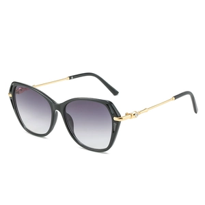 Lunettes de soleil œil-de-chat noires géométriques avec branches dorées et verres dégradés
