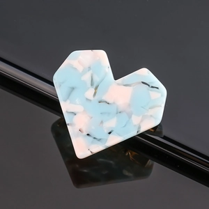 Macro shot of heart-shaped acetate hair clip with blue and pink terrazzo marble pattern