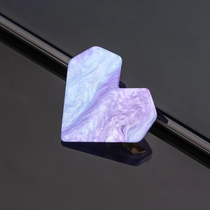 Detailed macro shot of a purple heart hair clip with marble texture and glitter finish