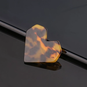 Close-up of heart-shaped hair clip featuring stylish tortoiseshell acetate patterns