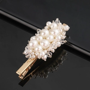 Macro detail of gold hair clip with hand-woven white pearls and clear crystal beads