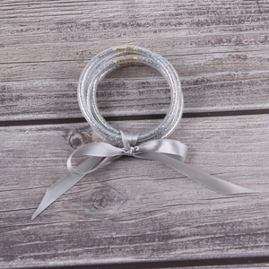 Set of silver glitter silicone jelly bangles featuring a grey satin ribbon bow and gold clasp