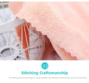 Close-up of pink coral fleece towel edges with fine stitching and soft microfiber texture