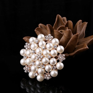 Detailed view of an elegant flower brooch with pearls and diamonds on a gold base