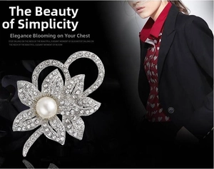 Detail of flower brooch with white pearls and sparkling rhinestones on model's coat