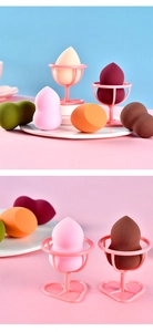 Macro shot of assorted makeup sponges in various shapes and colors with drying rack