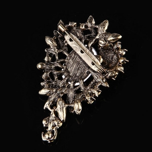 Detail of the vintage bronze flower brooch showing the secure pin clasp and hollow pattern