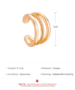 Detalle de un ear cuff geométrico dorado que muestra la textura y la medida de 1 cm