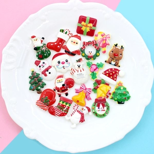 Diverses breloques de Noël en résine avec Père Noël et sapin sur assiette blanche