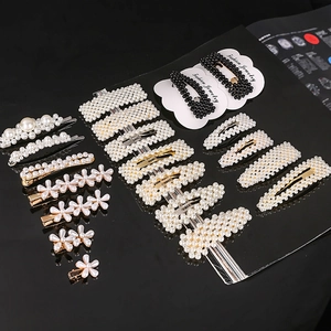 Detailed view of pearl hair clip set with white and black imitation pearls on metal